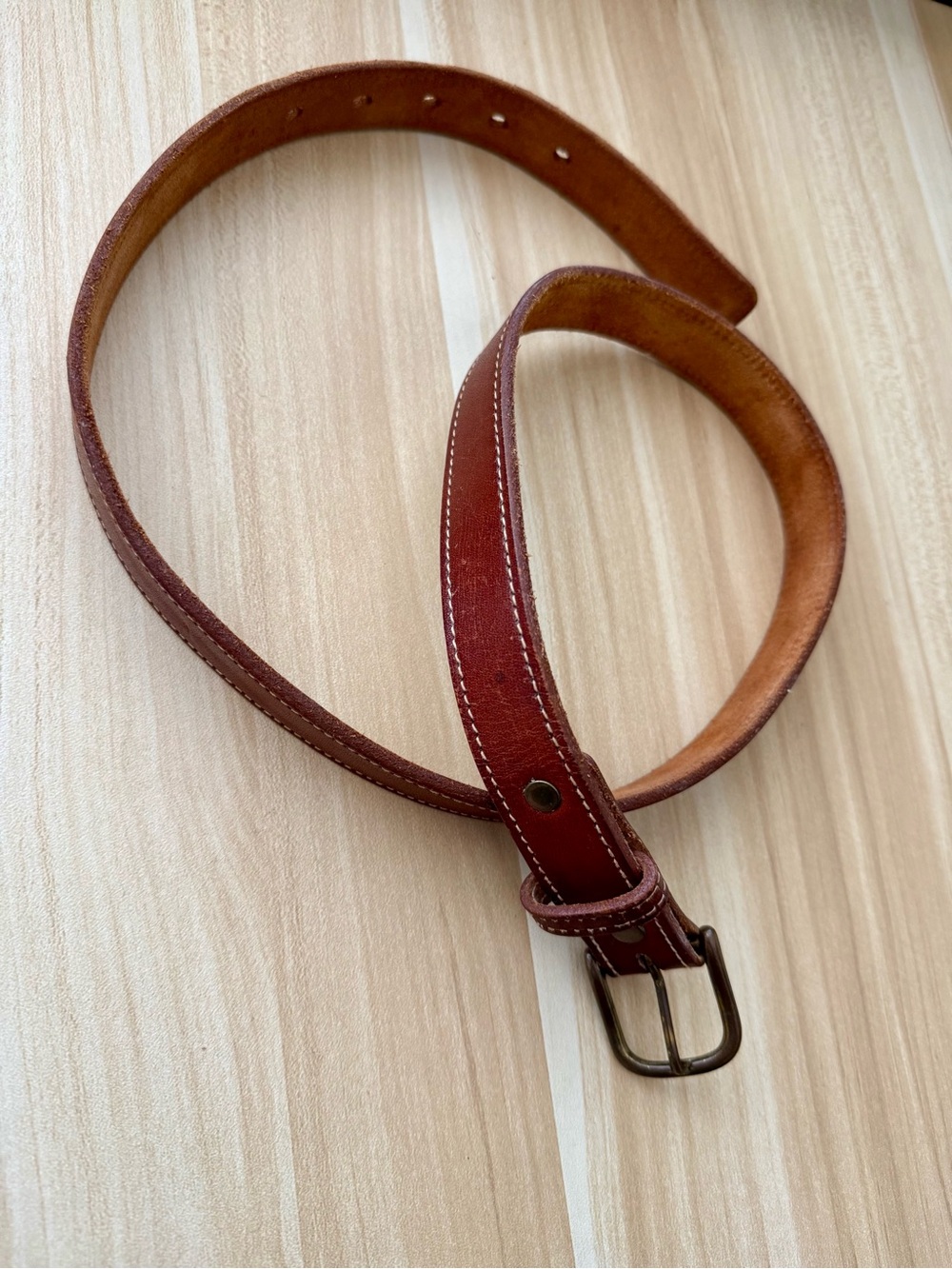 Brown leather belt with white stitching detail